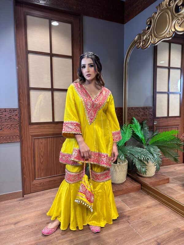 Mango Shaded Pakistani Anarkali Garara Suit with Appliqué Crafting and a Cute Potli.